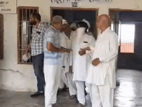 पंचायत के बाहर कमरे से बाहर निकलते ग्रामीण।