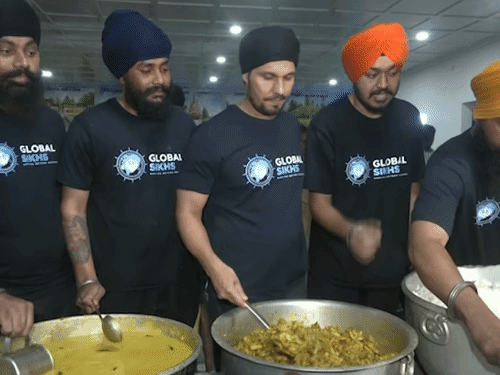 असम में बाढ़ पीड़ितों को खाना बांटते रणदीप हुड्डा।