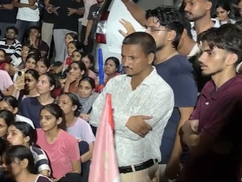 वाइस चांसलर ऑफिस के सामने बैठे छात्र।