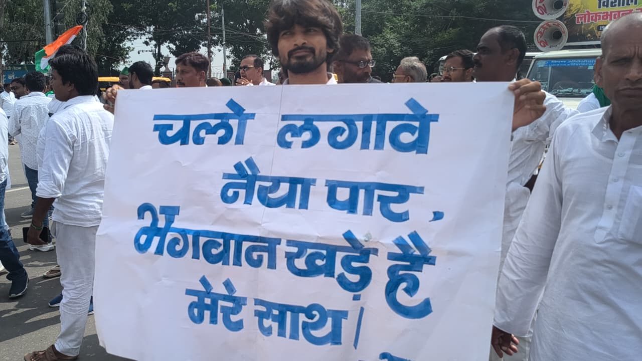 चलो लगाएं नैया पार, भगवान खड़े हैं मेरे साथ का पोस्टर लेकर पहुंचा कार्यकर्ता।