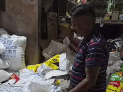 A shopkeeper weighing sugar in Sonipat.