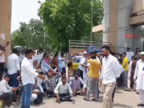 एमडीयू गेट पर बैठकर नारेबाजी करते छात्र।
