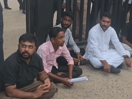 यूनिवर्सिटी कैंपस के बाहर धरने पर बैठ अभ्यर्थी।