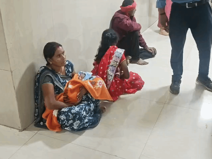 अस्पताल में वॉर्ड के बाहर बैठे बच्चों के परिजन।