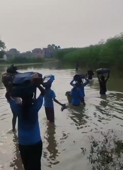 In Khagaria, Bihar, the water of the Ganges has reached the village. Children are forced to go to school with bags on their heads.