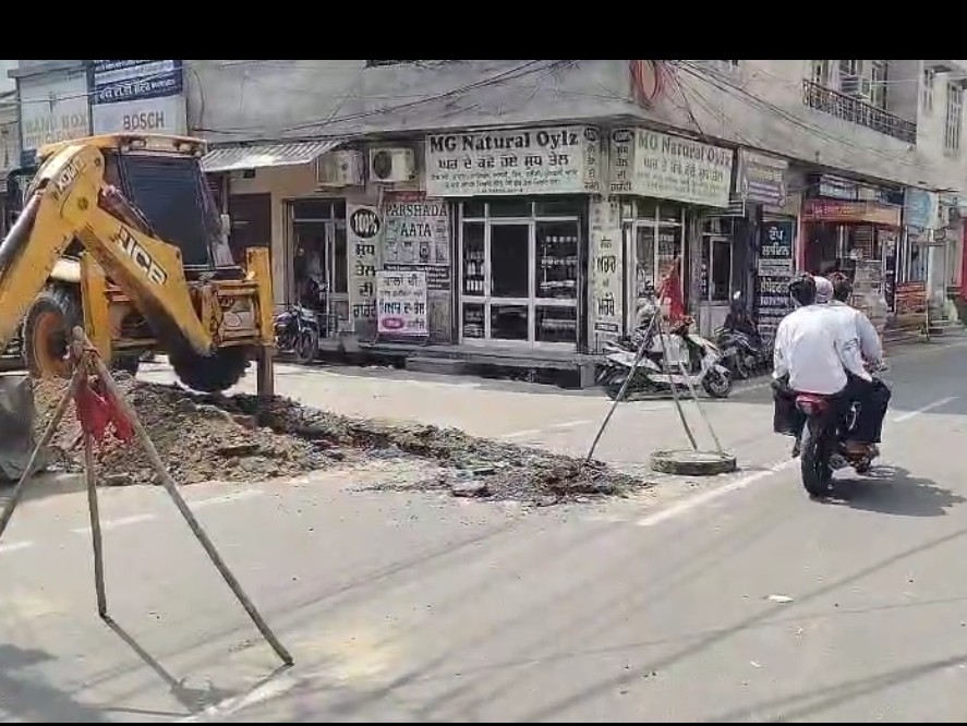 कच्चा कॉलेज रोड पर गवर्नमेंट स्कूल के पास बनी नई सड़क को जेसीबी से उखाड़ते हुए कर्मचारी।