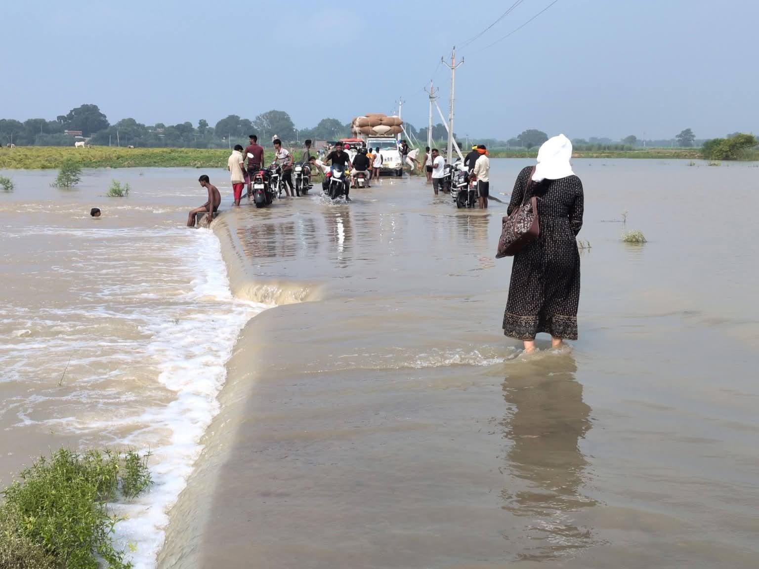 Eighty-two roads have been submerged due to floods in Ganga in Buxar, Bihar. People are crossing the road risking their lives.