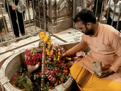 अचलेश्वर महादेव का पूजन करते मंदिर के पुजारी।