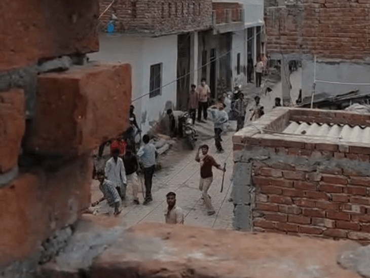 हाथ में हथियार पकड़े ईंट पत्थर चलाते हमलावर।