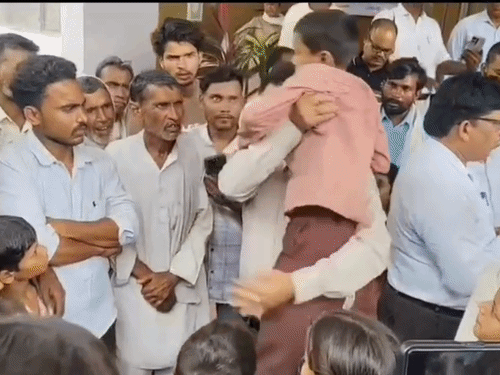 बीएसए राहुल मिश्रा ने एक बच्चे को गोद में उठाकर समस्या पूछी और जल्द समाधान का आश्वासन दिया।