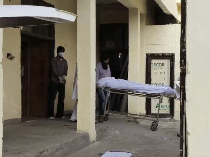 मॉर्च्युरी से व्यक्ति का शव लेकर आते परिजन।