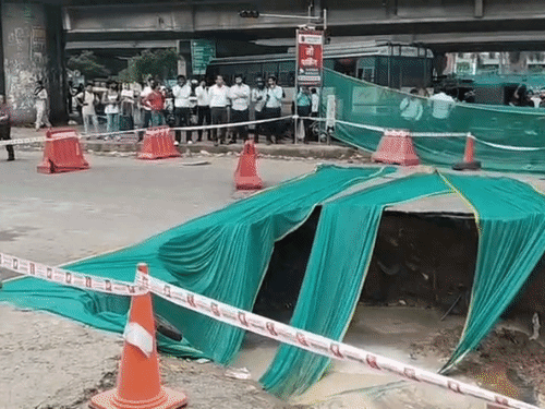 गुरुग्राम में इफको चौक पर धंसी सड़क और पुलिस की ओर से बैरिकेड लगाकर रास्ता बंद किया गया।