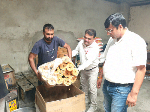 दुकान में खराब घेवर नष्ट करते हुए खाद्य विभाग की टीम।