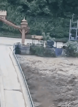 बाढ़ के बाद त्रिशूली नदी के किनारे पानी के तेज बहाव में एक पुल बह गया।