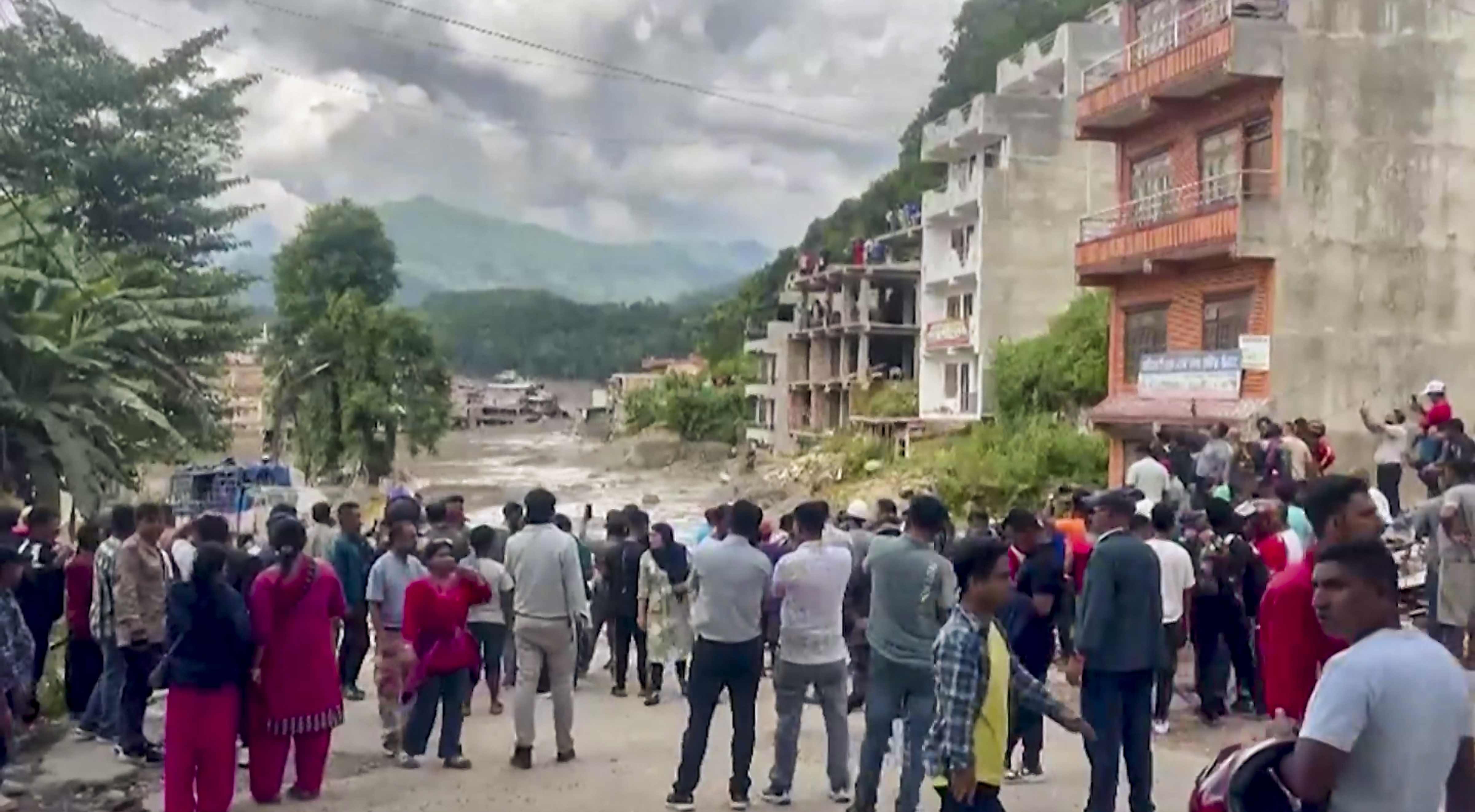 भोटेकोशी नदी में अचानक आई फ्लैश फ्लड के बाद रिहायशी इलाके से तेज रफ्तार में गंदा बाढ़ का पानी बहता हुआ।
