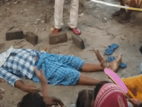 हत्या वाली जगह को कवर कर जांच करती पुलिस टीम।