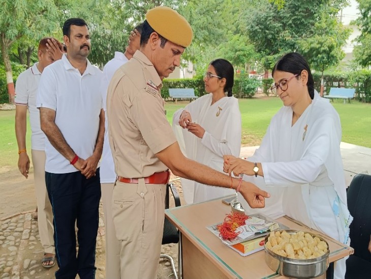 पुलिस जवानों के राखी बांधती ब्रह्मकुमारी।