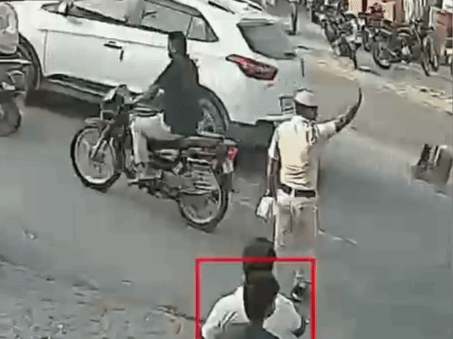 महिला ड्राइवर को कार रोकने के लिए कहते हुए होमगार्ड।