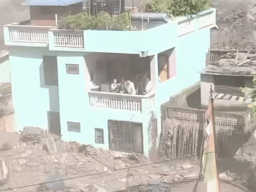 घर के चारों तरफ तेजी से बहता मलबा दिखाई दे रहा है।
