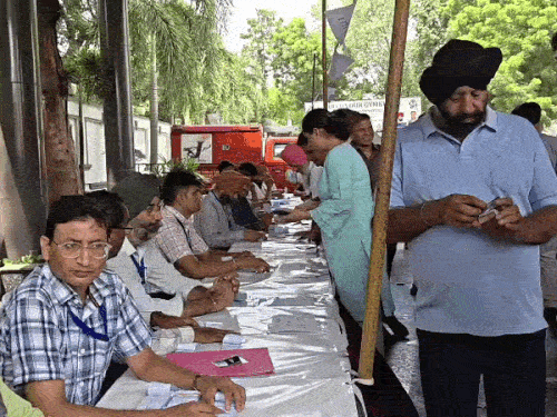 जिमखाना क्लब चुनाव में वोटिंग के लिए पहुंचे मेंबर अपने नाम की पर्ची लेते हुए।