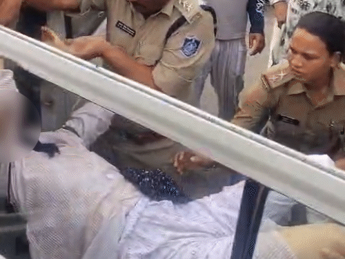शव को पोस्टमॉर्टम के लिए ले जाते हुए पुलिसकर्मी।