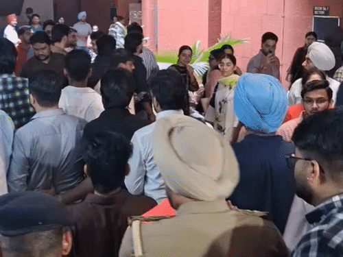 नारेबाजी कर रहे स्टूडेंट्स को पुलिसकर्मी उठाकर ले जाते हुए।