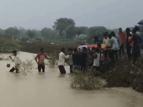 बारिश में अंतिम यात्रा के लिए शव को श्मशान घाट तक जाने के लिए कमर तक पानी को पार करना पड़ता है।