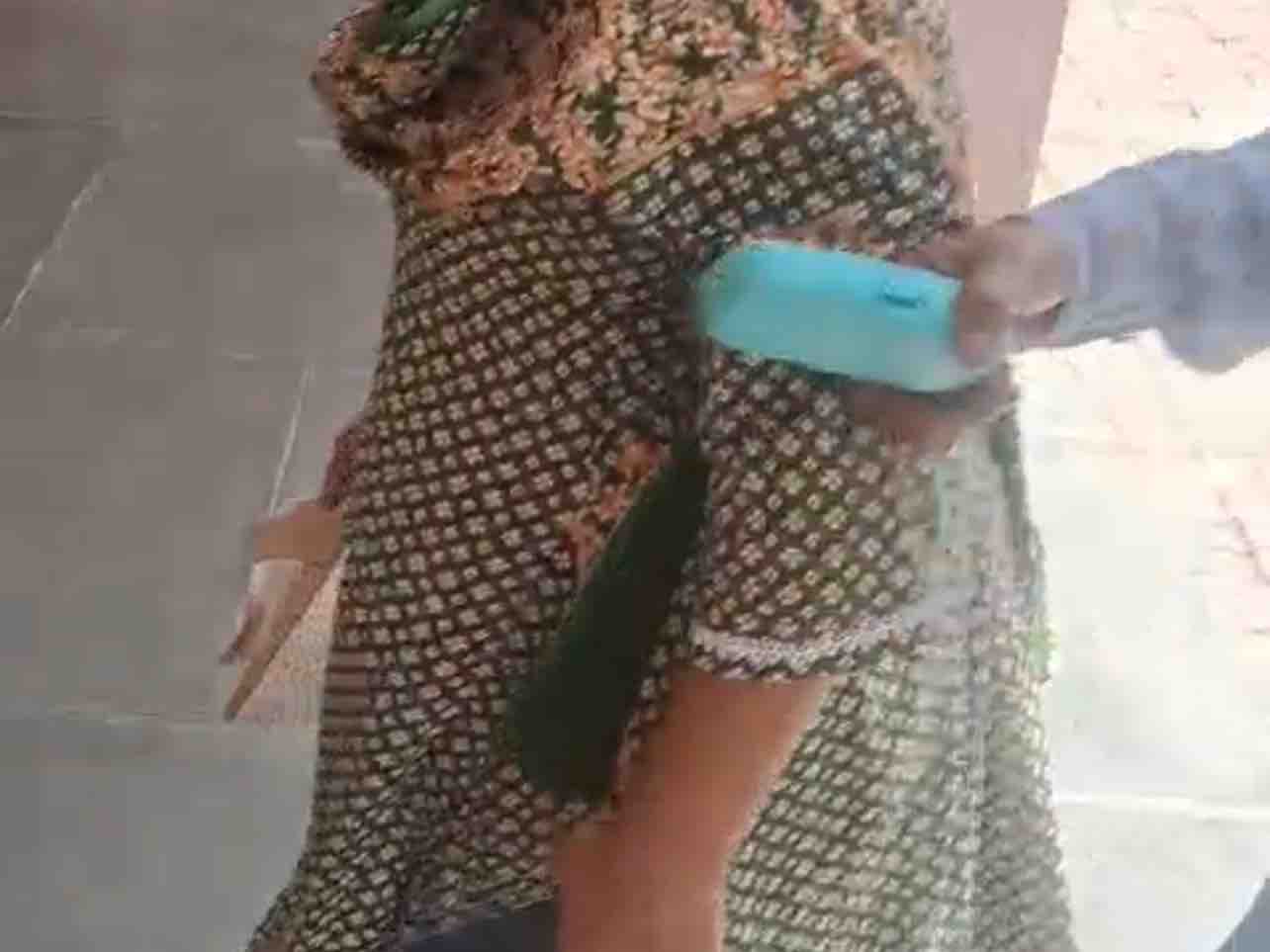हाथ में चप्पल लिए महिला BLO।