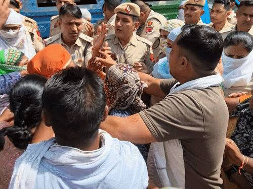 पुलिसकर्मियों से उलझतीं महिला सफाईकर्मी।