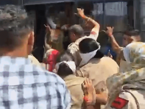 प्रदर्शनकारियों को बस में बैठाते पुलिसकर्मी।
