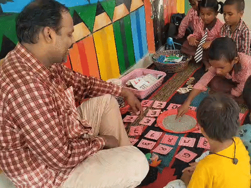 बच्चों को खेल -खेल में पढ़ाते हुए पंकज द्विवेदी।