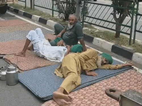 मोहाली-चंडीगढ़ बॉर्डर पर किसान आंदोलन के दौरान सड़क किनारे आराम करते किसान।