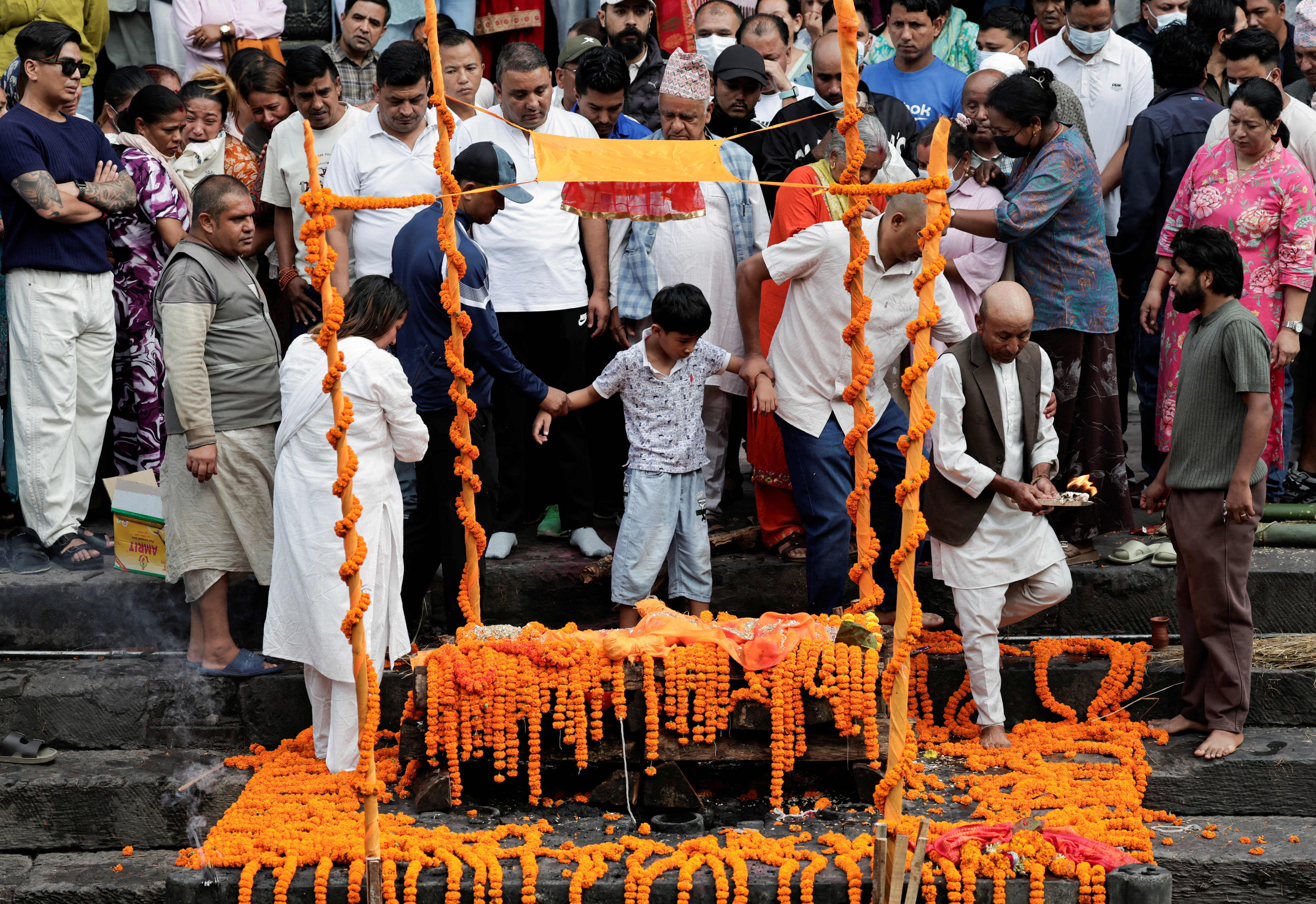 पिता के अंतिम संस्कार में शामिल होता उनका बेटा।
