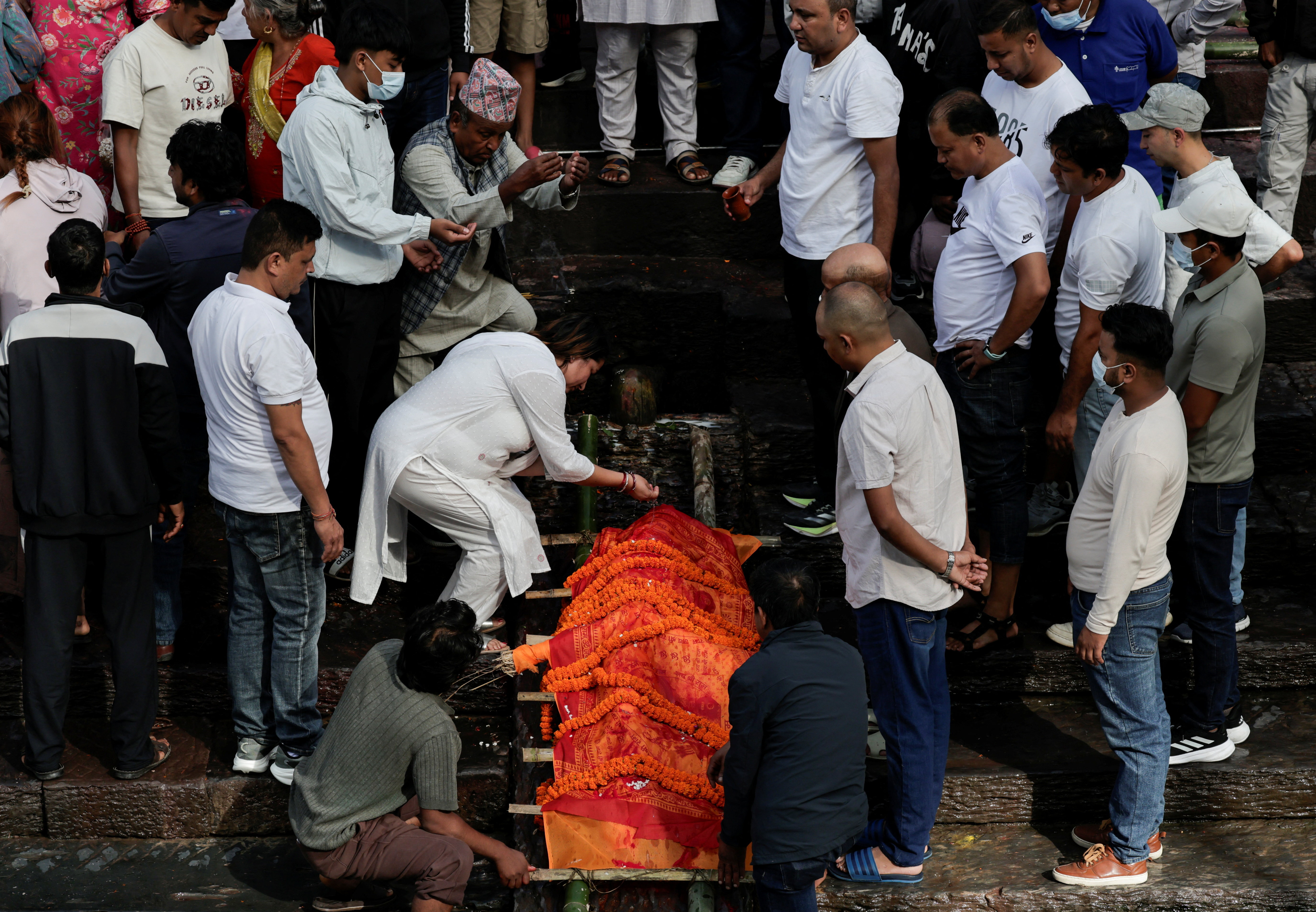 सूरज तिमिल्सिना के पुतले के साथ अंतिम संस्कार की रस्में निभाते परिजन।