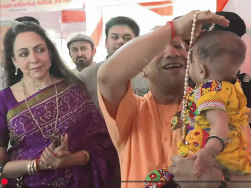 सीएम योगी ने बच्चों को गोद में लेकर दुलारा। उनका अन्नप्राशन कराया। इस दौरान पीछे खड़ी सांसद हेमा मालिनी मुस्कुराती रहीं।