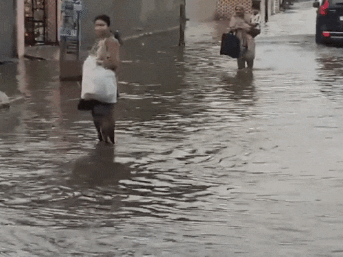 अंबाला में सड़क पर दो से तीन फीट तक पानी भर गया। सड़क पर हुए जलभराव से होकर जातीं महिलाएं।