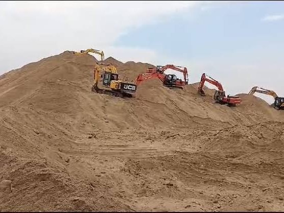 रेत का स्टॉक करती मशनें।