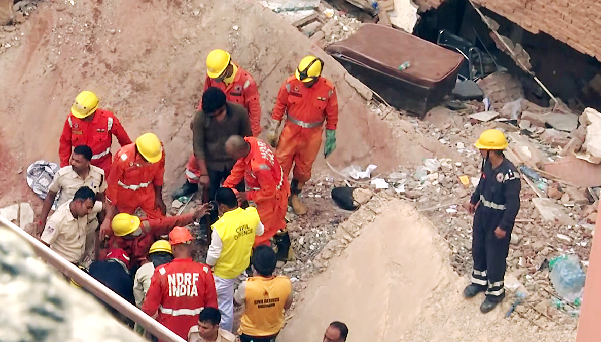 Rescue team and Delhi Police personnel searching for people in the debris.