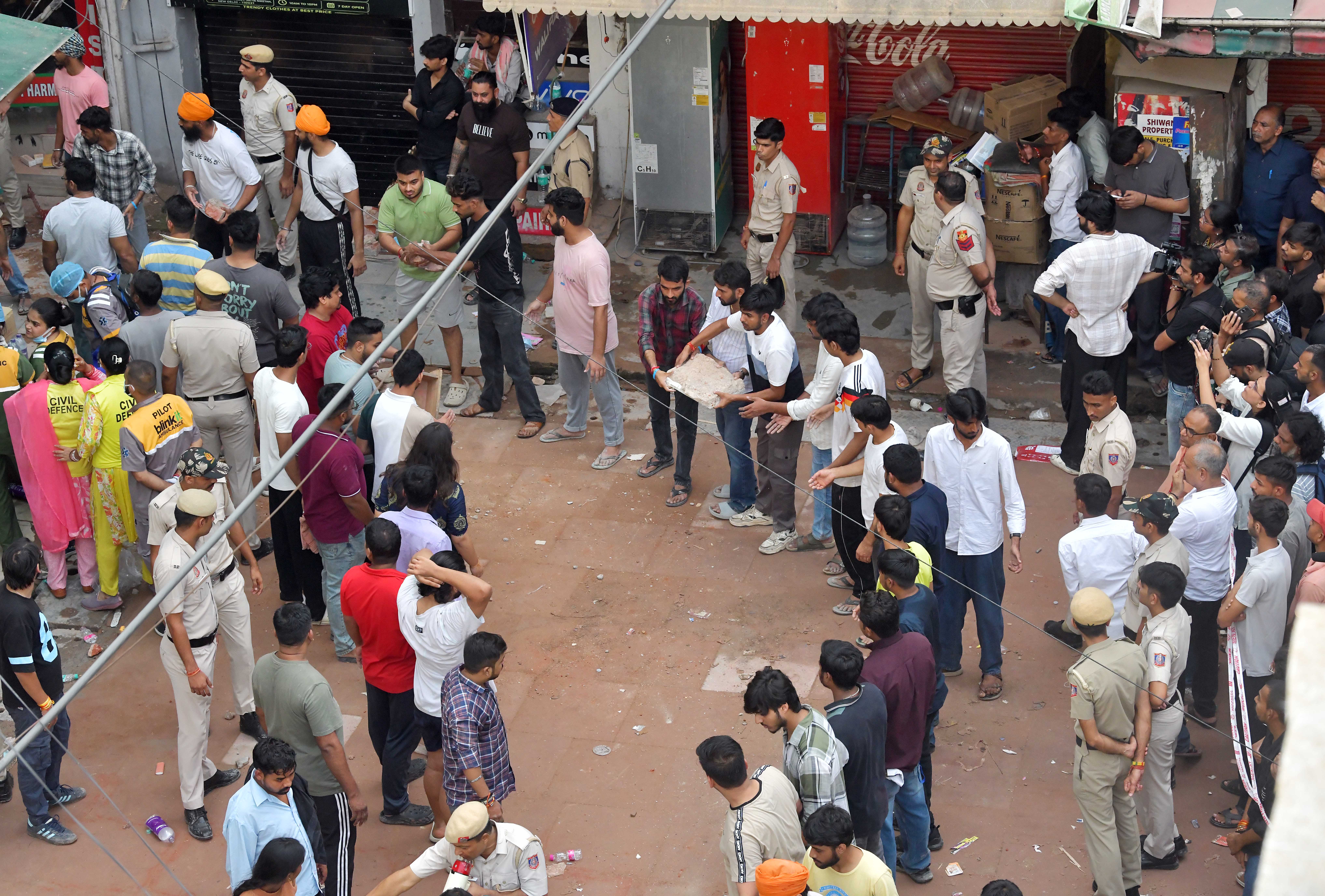स्थानिक आणि विद्यार्थी ढिगारा हटवण्यात बचाव पथकाला मदत करत आहेत.
