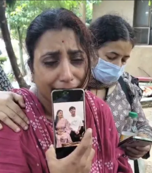 अक्षत की मां मोबाइल पर फोटो दिखाते हुए।
