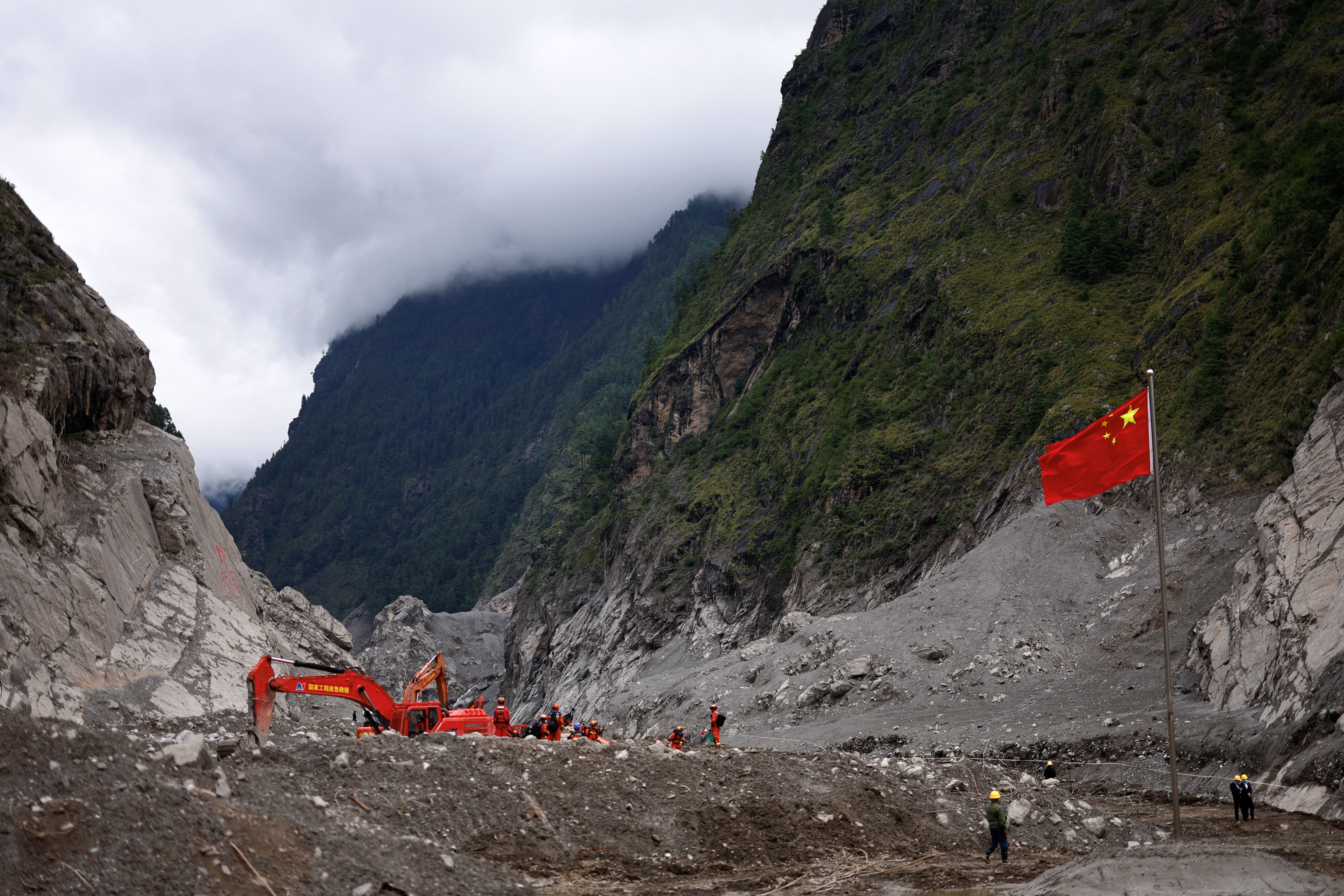 Rescue workers search for people under the debris near the Chinese flag at Gyirong Port in Tibet.