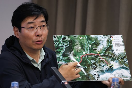 Chinese scientist Su Pengcheng giving information about the disaster at Gyirong Port in Tibet, along with a map of the China-Nepal border.