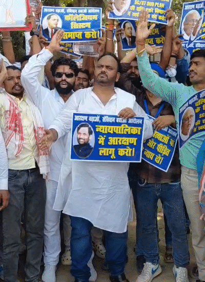 सुप्रीम कोर्ट में आरक्षण लागू करो, लिखे पोस्टर लेकर सड़क पर उतरे प्रदर्शनकारी।