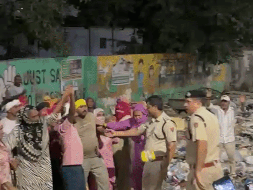 सफाई कर्मियों को हिरासत में लेत पुलिस वही विरोध में कूड़ा फेंकते सफाई कर्मचारी।