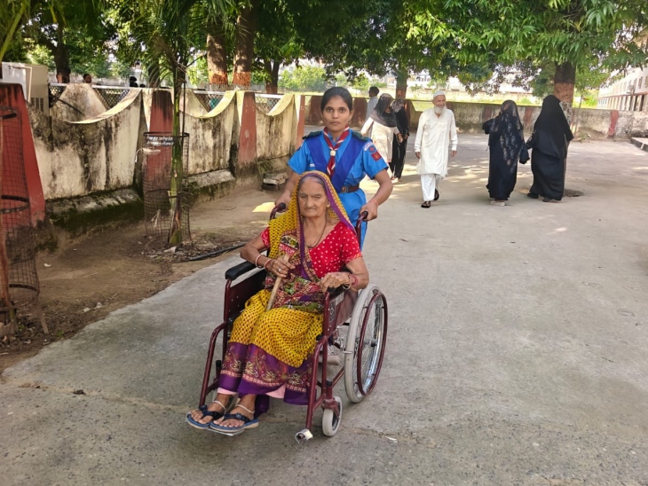 नीमकाथाना में वॉलंटियर्स बुजुर्ग मतदाताओं को व्हीलचेयर से बूथ तक लेकर जा रहे हैं।