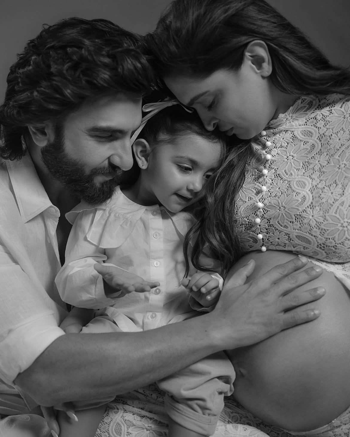 Dua looking at her mother's baby bump.