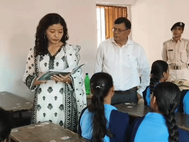 बच्चियों की नोट बुक चेक कर रही डीएम।