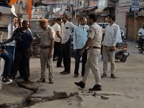 मतदान केंद्र के पास दुकानों को बंद करवाती हुई पुलिस।