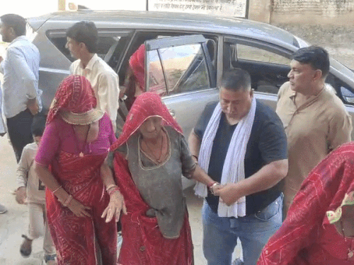 लक्ष्मणगढ़ के एक पोलिंग बूथ पर बुजुर्ग महिला को वोटिंग के लिए ले जाते परिजन।
