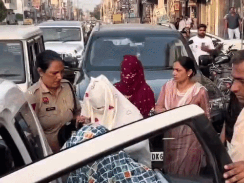 पकड़ी गई युवतियों को गाड़ी में बैठाती पुलिस।